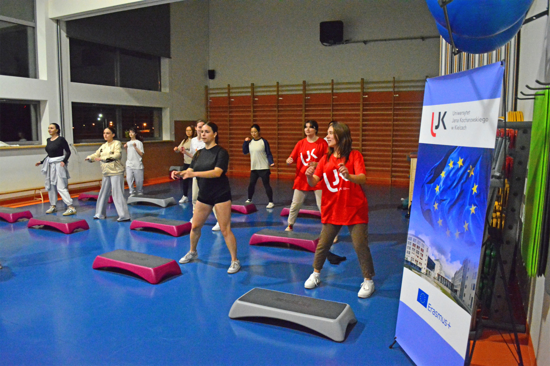 Grupa studentek ćwiczy w trakcie zajęć fitness.
