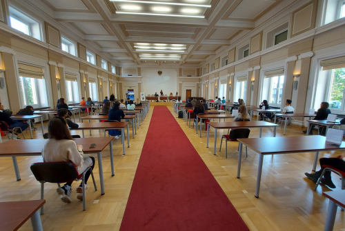 Studenci siedzą. W centrum widać prezentujących koordynatorów.