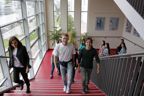 Uśmiechnięci studenci wchodzą po schodach
