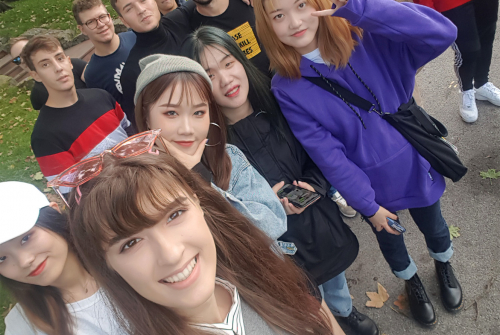 Uśmiechnięta grupa studentów robi selfie.