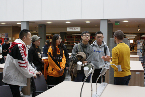 Studenci z Chin słuchają pana przewodnika w Bibliotece UJK.