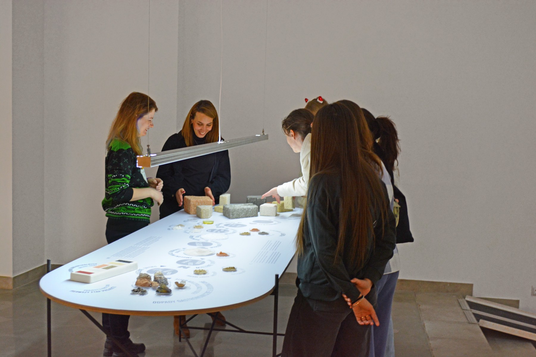 Studentki stoją wokół stołu z eksponatami.