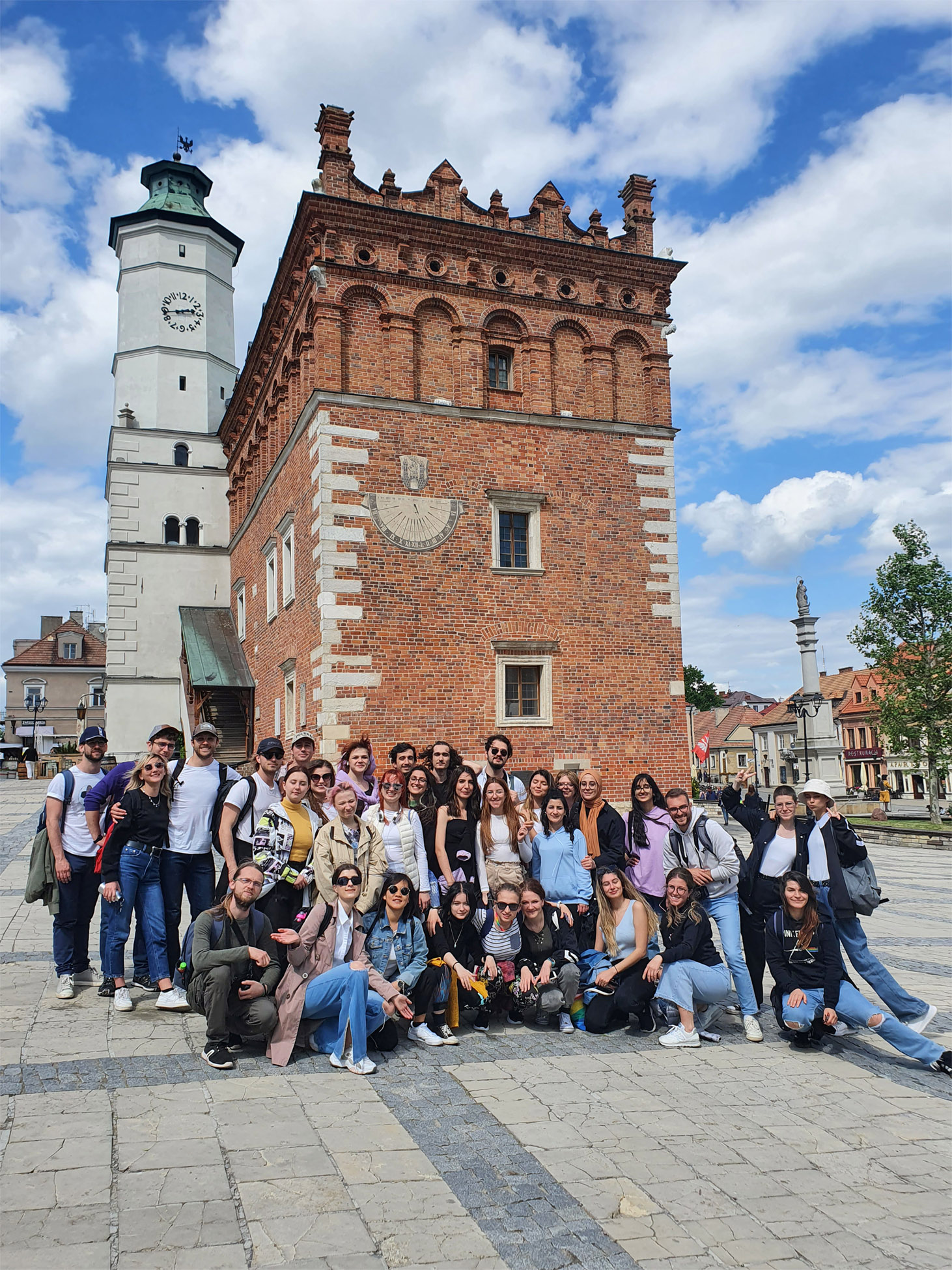 Zdjęcie grupowe studentów. W tle ratusz w Sandomierzu.