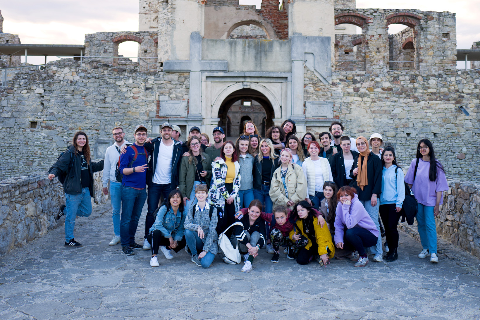 Zdjęcie grupowe studentów. W tle ruiny zamku Krzyżtopór.
